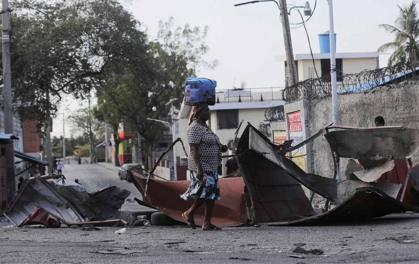 A woman walks past a barricade amid gang violence in Port-au-Prince on 3 March 2023..